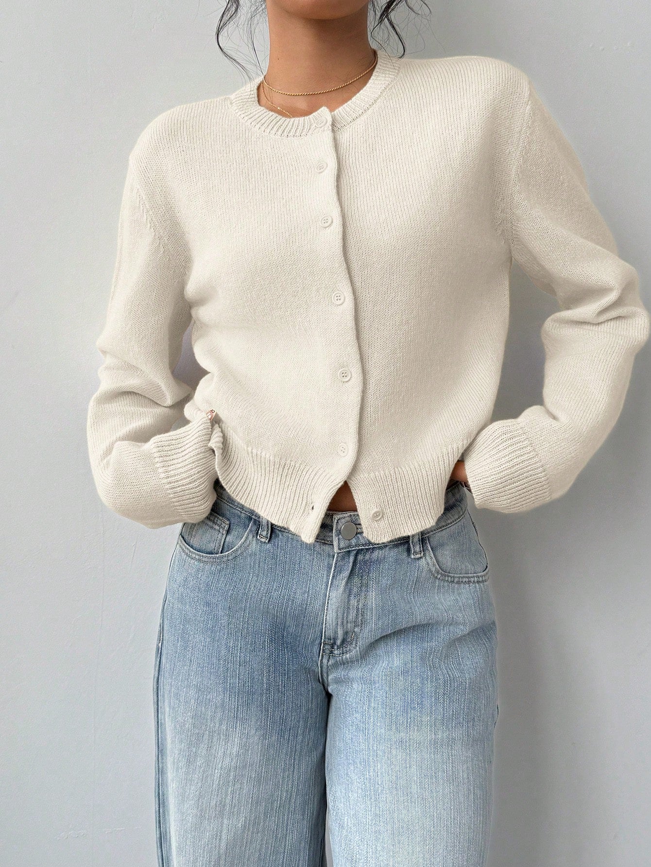 Close-up of soft solid color knitted fabric texture on a long sleeve short cardigan.