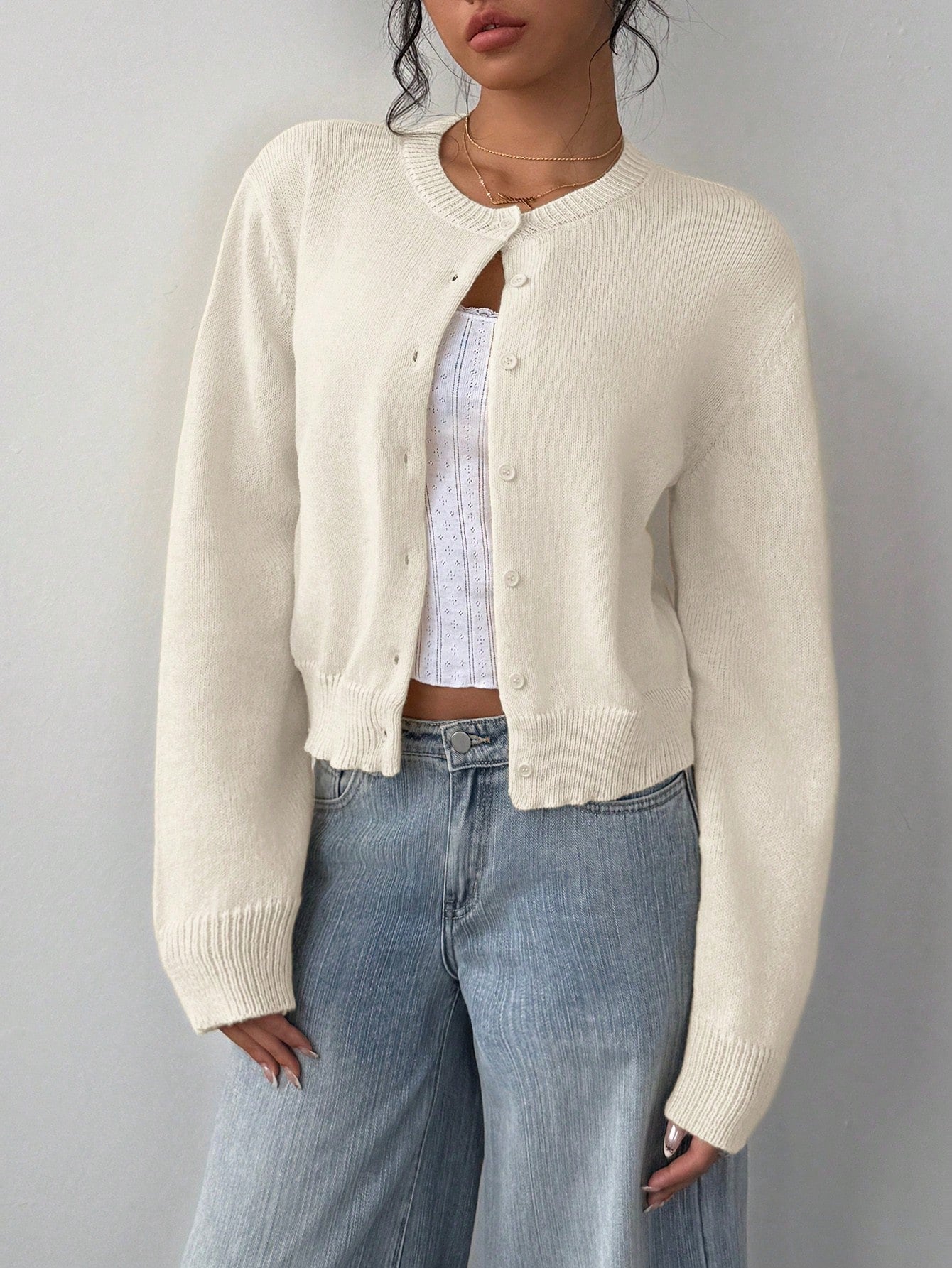 Close-up of soft solid color knitted fabric texture on a long sleeve short cardigan.