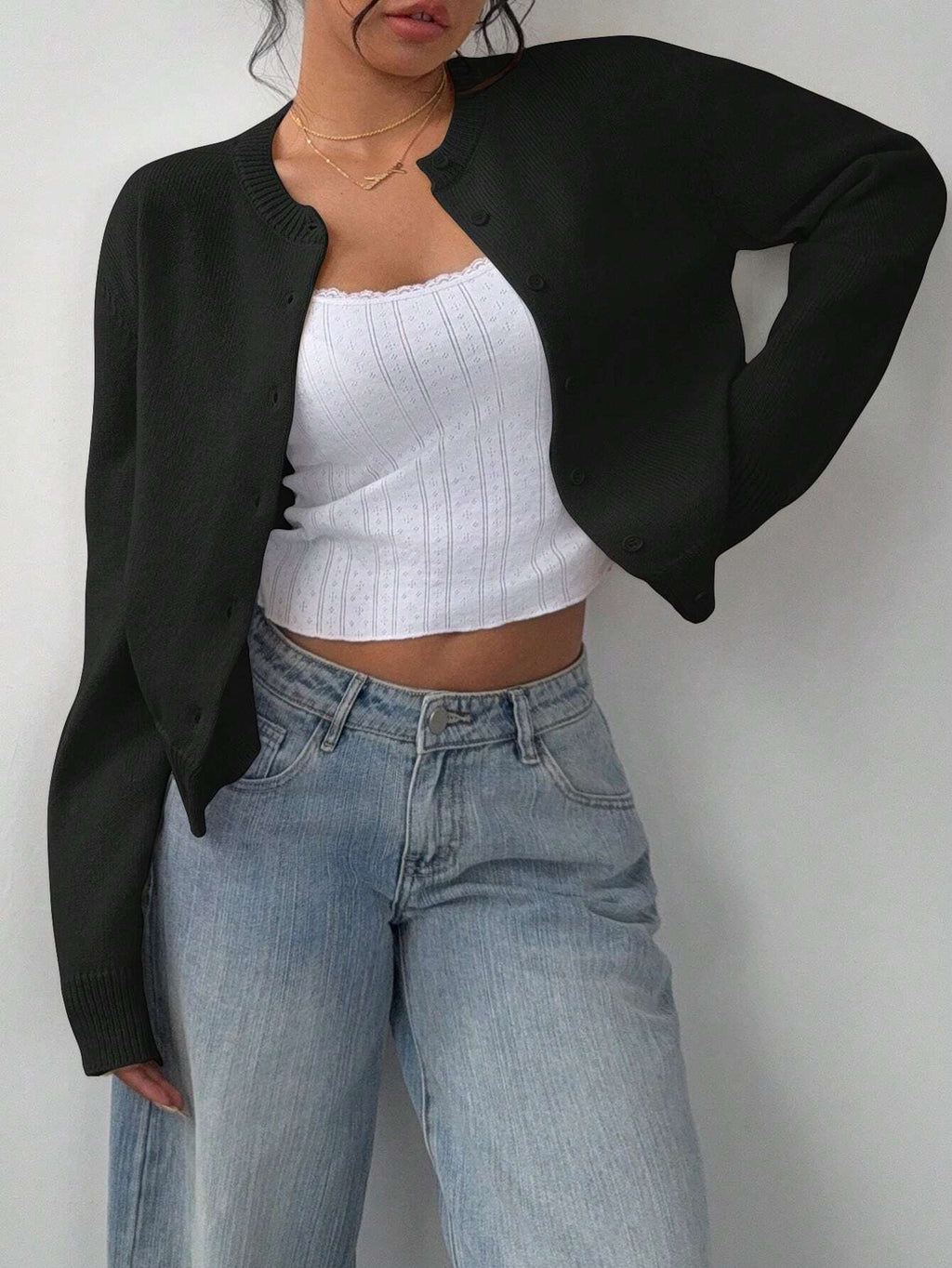 Model wearing an open-front solid color short cardigan over a camisole.
