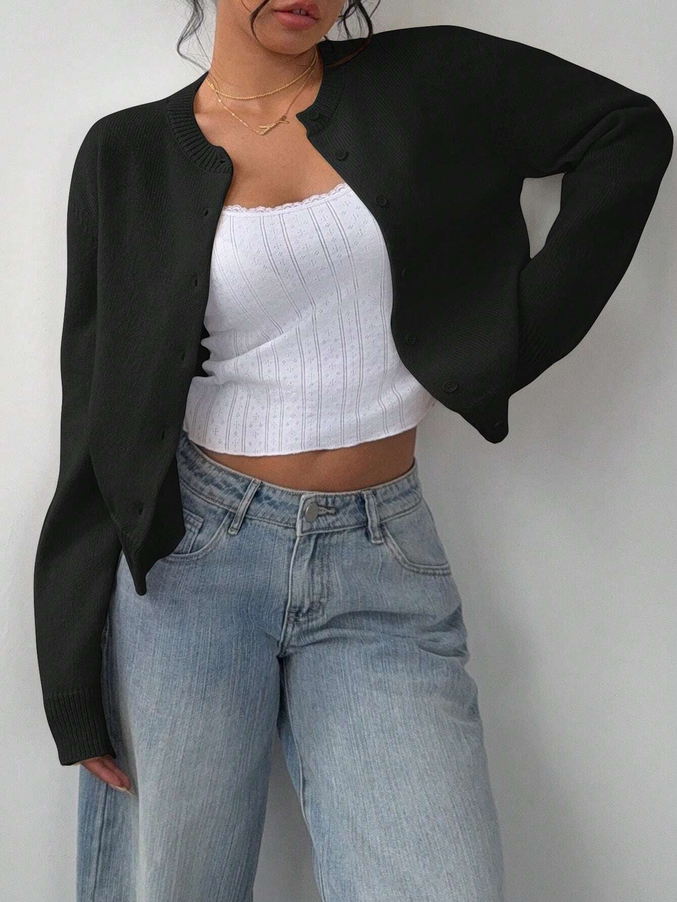 Model wearing an open-front solid color short cardigan over a camisole.