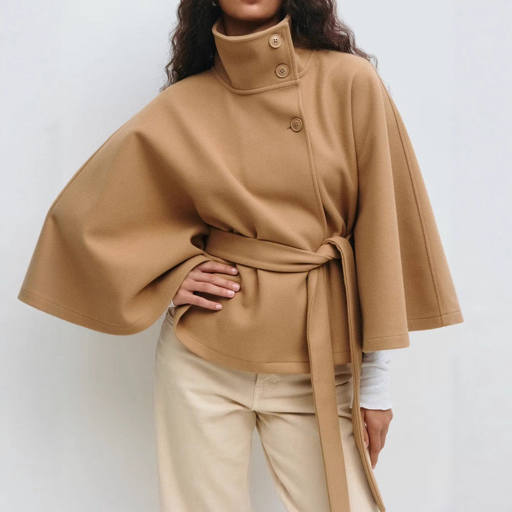 Model wearing high neck batwing sleeve trench coat, belted at the waist in Biege